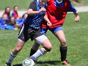 Miranda Lantz of the Walkerton District Riverhawks, left, fights off Sarah Haefling of the West Hill Raiders during their BAA girls soccer match on Thursday at West Hill in Owen Sound. The Raiders won the quarterfinal game on penalty kicks and advance to play the Kincardine District Knights next week.