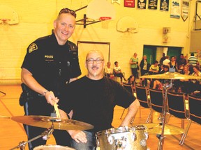 Constable Kevin Martin and drummer Mitch Dorge take a moment with Dorge’s drum set at Kincardine District Secondary School. Dorge spoke with students on how to make safe choices about drugs and alcohol at the school on May 16, 2013.  (ALANNA RICE/KINCARDINE NEWS)