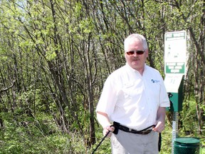 North Bay-Mattawa Conservation Authority CAO Brian Tayler and his dog, Teagh, stand near one of the new doggie-doo stations at the Laurier Woods. The authority and a number of partners have launched an effort to remind pet owners to keep their animals on leashes on local trails, as well as to clean up after them.