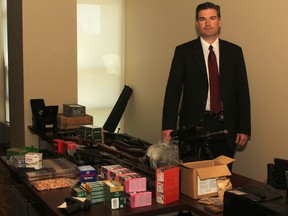 Kingston Police Det. Jay Finn displays a cache of weapons, explosives and ammunition seized at a Montreal Street residence Thursday.