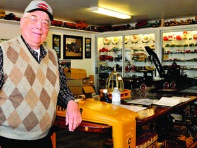 Tackaberry Construction owner George Tackaberry leans against an oak table built from parts of a Caterpillar bulldozer, foreground, and a Mack Truck Bulldog, a prized possesion that was a gift from a fellow collector. Tackaberry's private collection of vehicles and equipment will be on display for the first time during Doors Open Ontario next weekend. NICK GARDINER The Recorder and Times