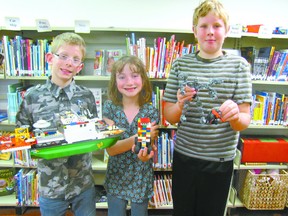 Three of the four winners of the Mayerthorpe Public Library Lego Contest show their prize-winning creations on awards day Wednesday, May 10. William McDowell, the Fan Favourite with The Ship, Laura Jager, in the ages seven to nine category, with her Robot Garbage Taker, and Treyton Mason, in the ages 10+ category, with his Champ and Squat. The prizes? More lego.