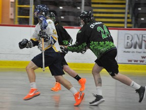 The Brockville Ballistic's Jarrett Pitt (12) rushes forward in an offensive drive while the Clarington Shamrocks Tyler Blumbergs and Mark Henshall (24) try to block him in second-period Junior C lacrosse action at the Brockville Memorial Centre Sunday afternoon. RONALD ZAJAC The Recorder and Times