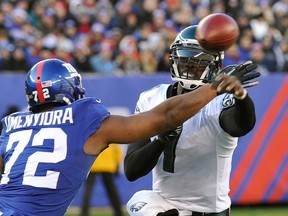 Philadelphia Eagles quarterback Michael Vick throws a pass as he is rushed by New York Giants Osi Umenyiora during NFL action in East Rutherford, New Jersey, December 30, 2012. (REUTERS file photo)