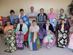 Representatives from the Northern Lights Quilt Guild and the cancer ward of the Melfort Hospital show off some of the quilts donated by the guild.