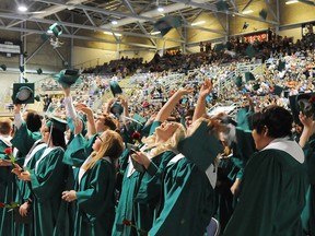 Graduates of the 2013 St. Joseph Catholic High school class throw their caps in the air at the end of the commencement in the Canada Games Arena, Saturday. Close to 200 students graduated.  Aaron Hinks/Daily Herald-Tribune