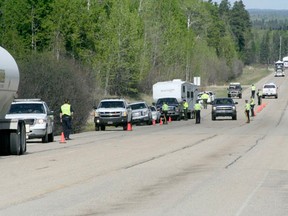 Law enforcement officers check vehicles heading west on Highway 620 at a police checkstop just outside of Lodgepole. Officers were joined by commercial vehicle enforcement and fish and wildlife in the checkstop, which, according to Staff Sgt. Brian Jones, was set up to educate long-weekend revellers as they headed out camping for the May long weekend.