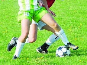 Tara Chadwick of Stratford CT Ladies (red jersey) battles for a ball with a Waterloo Wildfire player during Monday night's Southwest Region Soccer League Ladies Premier game at Packham Soccer Complex. Stratford won 3-0. (STEVE RICE The Beacon Herald)