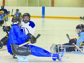 Trent Cross of Cold Lake assists Lakeland Sports and Learning Academy students with the ins and outs of sledge hockey during their May 15 wrapup at J.J. Parr.