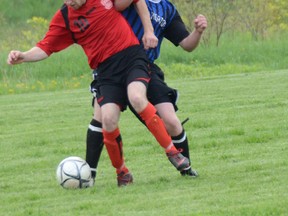 Sacred Heart's Chris Weaver (left) hooks arms with the Walkerton District Riverhawks Nelson Gayman (right) in the Crusaders' 3-1 penalties on Tuesday in the Bluewater Athletic Association senior boys soccer final.