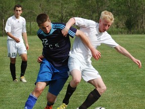 Assumption's Andre Toic and Andrew Misner of St. John's battle for the ball during the Brant County boys soccer final Tuesday at John Wright Field. (DARRYL G. SMART, The Expositor)