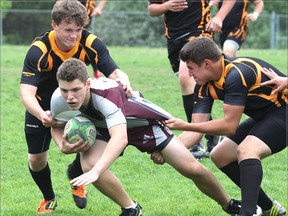 Frontenac Falcons’ Braeden Stevenhaagen is slowed down by La Salle Black Knights Harry Stone and Bryson Johnson during senior rugby semifinal action Tuesday afternoon at Frontenac. The Black Knights won 26-19. (Michael Lea/The Whig-Standard)