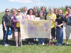 STEPHEN UHLER    Money raised during the recent relay held at the school is going towards the school’s faculty Relay for Life team, which was made a member of the 5K Club for raising more than $5,000 at last year’s relay event. Holding the banner in front are, starting from left, Bishop Smith Catholic High School student Danielle Swant, cancer survivor, team captains Patty Ladouceur and Dona Dominey, Jordan Davidson, another cancer survivor from BMCHS. Standing behind them are team members, starting from far left, Jessica O’Dell, Shania Keuhl, Renee Wilson, Sara Ward, Kathy Turcotte, Paulette Medeiros, Leanne Hall and Michael Austen. Missing from the photo are Lynn Wright-MacDougall ad Dan Stone.