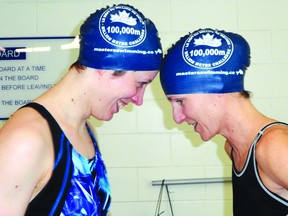 Riley Sleeman left, and Holly Friesen right, stand head to head with their new 100,000 m swim caps showing they’ve reached the first milestone of the Million Meter Challenge. The challenge requires athletes to swim 1,000,000 meters over their regular practice schedule with prizes along the way for big milestones such as the 100,000-m mark.