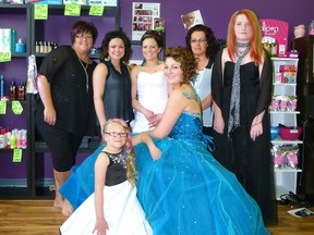 Obrigewitch (far left) with daughter Shelby Schwerdt (second left) who is taking over Roots and turning the salon into a more family friendly place. The salon held a grand re-opening with models to show what they can do: Brittany Peterson in bridal gown, Amy Friedel in blue (showing glitter tattoos) and flowergirl Nevada Gerk. Schischikowsky (second from right) and Fay Skoyen (far right) are among the staff ready to show you what they can do. Chris Eakin/Fairview Post