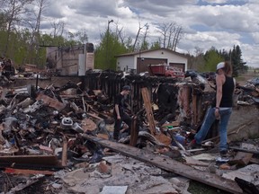 Ingrid Henschell and her son Chris, went through the remains of her parent’s home near Beaumont. A fire on May 14 had firefighters working through the night. ADAM HODNETT QMI AGENCY