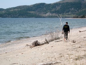 A hiker enjoys a barefoot stroll along the beach at Agawa Bay campground in Lake Superior Provincial Park on Saturday of the long weekend.