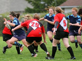 West Hill Raiders' Laura McKenzie charges through a pack of Sacred Heart Crusaders opponents during the BAA girls semi-final rugby match on Wednesday in Owen Sound. The Raiders won the match 34-0 to advance to the final which was canceled due to poor drainage on the field.