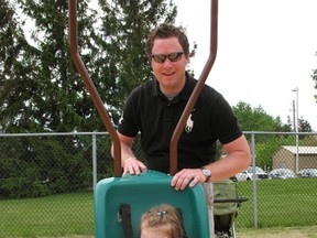 Two-year-old Sydney gets a push on the swing from her father Dan Lundy at the new accessible therapy playground at the Chatham-Kent Children's Treatment Centre.