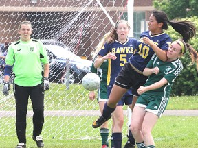 Napanee goalkeeper Kayla Kennedy and teammate Bronwyn O'Neill look  on as Napanee's Sarah Fabius leaps to head away the ball from a corner kick over top of Holy Cross's Grace Esford during girls semi-final soccer at Holy Cross Wednesday afternoon. Holy Cross won 4-2.
Michael Lea The Whig-Standard