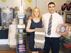 Shannon Trudeau and her husband, Yilmaz Acar, stand in their brand new boutique, Tricot Treat Imports, during the grand opening recently at 17 1/2 Second St. East. Success with their online store prompted the couple to open their own small shop . 
Staff photo/ERIKA GLASBERG