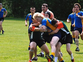 BCI ball carrier Ryan Blunt is tackled by North Park players on Thursday on the George Jones Fields at the Harlequins Grounds in a Brant County high school senior boys rugby semifinal game. BCI won 41-5.