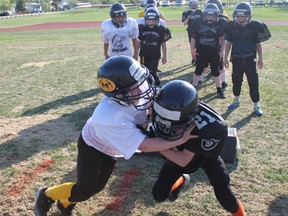 The Fort McMurray Peewee Minors Ryan Crawford collides with Anzac Wolves’ Cain Scott-McKenzie during a lineman drill at the Coach Wood Memorial Camp Wednesday night. TREVOR HOWLETT/TODAY STAFF