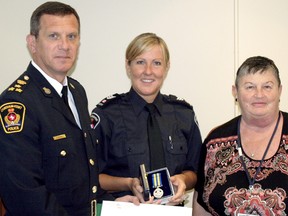 Sgt. Cathy Graham, center, of the Chatham-Kent Police Service was presented with the Police Exemplary Service Medal by Chatham police Chief Dennis Poole and Pat Belanger, chair of the Chatham-Kent Police Services Board during a Chatham-Kent Police Services Board meeting. (KIRK DICKINSON, For the Daily News)