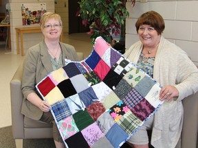 Karen Lambert (right) of the Alzheimer's Society presents a 'touch quilt' to Margaret Warner, a social worker at Lions Prairie Manor in Portage la Prairie. The North Central Region office has received quilts donated by Fairholm and Elm River Hutterite Colonies which they have in turn donated to long term care facilities in the area. Touch quilts are made of different colours and textures of fabric with added pieces like zippers, buttons, and strings to enhance touch and comfort. (SUBMITTED PHOTO)