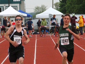 Jordan Nichols (right) from St. John's College outstretches Brandon Metz from Simcoe's Holy Trinity at the finish line in the midget boys 100-metre final during the Central Western Ontario Secondary School Association track and field championships at Jacob Hespeler Secondary School in Cambridge Thursday. (DARRYL G. SMART, The Expositor)