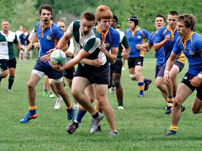 Greg Roberts of St. John's pitches the ball to a fellow player while BCI defenders Nick Linesman and Zack Morrison go in for the tackle Thursday during the high school senior boys championship game. (KARA WILSON, for The Expositor)