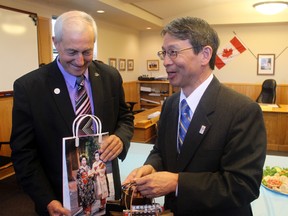 Japan Consul General Eiji Yamamoto (left) brings gifts for they ayor and others who came to meet him on Thursday at City Hall.  Mayor Dave Canfield was given a silk tie from a from textile company that was renounded for centuries for their silk kimonos.  
ALAN S. HALE/Daily MIner and News