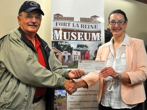 Portage la Prairie Mutual Insurance Co. board member Tom McCartney presents a $2,000 cheque to Tracey Turner at the Fort la Reine Museum on May 17. The money is the first donation to the museum’s new capital campaign. (CLARISE KLASSEN/PORTAGE DAILY GRAPHIC/QMI AGENCY)