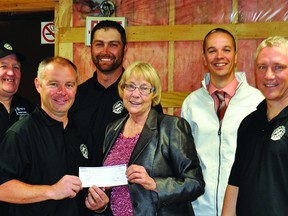 Bridget Pastoor, MLA for Lethbridge-East, presents a cheque for $19,500 to Sean Carey, president of the Vulcan Kinsmen Club, on May 23 in the club’s meeting area. The cheque will help pay for the cost of fixing up the room, which has flooded three times in the past three years.  Also pictured are, from left, Kinsmen Brian Rodgers, Stewart Surman, Derek Ully, Jarrod Shaw and Ken Garinger, and Little Bow MLA Ian Donovan. Stephen Tipper Vulcan Advocate