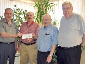 Tom McCartney, of Portage la Prairie Mutual Insurance Co., second from left, hands a cheque for $3,000 to Portage Heritage Inc.'s Vic Edwards, left, Bob Jones and Howard Barker. The money will go towards renovation projects at the historic CP Railway Station. (CLARISE KLASSEN/PORTAGE DAILY GRAPHIC/QMI AGENCY)