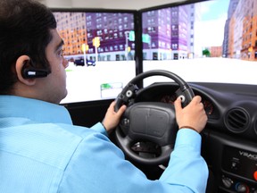 Mayank Rehani demonstrates the driving simulator used to study the impact of hands-free distraction on drivers at the Glenrose Rehabilitation Centre in Edmonton on May 24, 2013. Dave Lazzarino/Edmonton Sun/QMI Agency