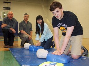 Timmins High & Vocational School was pumped up to receive four new defibrillator (AED) units courtesy of TransCanada and the ACT Foundation on Friday. Having AEDs on site and people trained to use them can increase to likelihood of surviving cardiac arrest by up to 75%. Among those touching up their first-aid knowledge on Friday were, from left, Mayor Tom Laughren, TransCanada representative Dan Stencill, and TH&VS students Jenna Wilson and Sam McPhail.