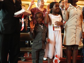 Benedict and Arianne Burume take their oath of citizenship at a ceremony last fall at Kingston's City Hall. Immigration laywer Leslie Morley argues that the city needs to attract more immigrants or risk being left behind, and suggests several courses of action to encourage this.
