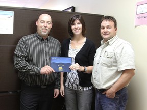 Bertin Gagnon, Freedom 55 financial security advisor presenting Angele and Joel Genier with the five day cruise they won.