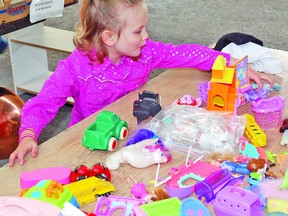 Mom Loralee Wyatt from the Arrowwood area brought her daughters Leah, 2, and Addison, 4, pictured here, to the 17th annual Arrowwood Community Garage Sale on Saturday. Addison could hardly contain her excitement from getting to pick 10 toys.