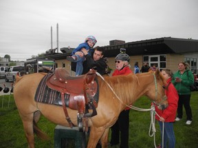 Boe Quenneville gets hoisted by step-father Antoine Boudrias on top of one of the riding horses provided by Drogheda Manor stables' owner Garry Meek, with the camera mounted hat, during the Bike-A-Thon-Plus, Saturday, May 25, 2013 in Cornwall, Ont. GREG PEERENBOOM/CORNWALL STANDARD-FREEHOLDER/QMI AGENCY