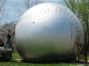 Keith Wilson does welding work on a water tower top being turned into a giant baseball in Muscotah, Kansas, April 30, 2013. Residents of Muscotah want to parlay the town's ties to native son Joe Tinker, a baseball Hall of Fame second baseman, by painting the top of an old water tower to look like a giant baseball and putting a museum inside to attract tourists. REUTERS/Kevin Murphy