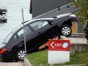 A car goes over the embankment at the parking lot of the Shoppers Drug Mart parking lot in Kenora on Saturday, May 25.