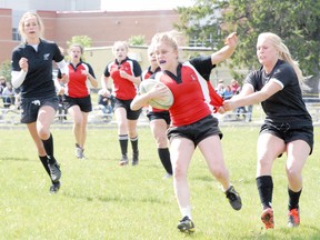 MONTE SONNENBERG Simcoe Reformer
Laramie Bradovka of Waterford bringing the ball up field while Holy Trinity Titans' Kaitlyn Vanderlee yanks her jersey during the NSSAA girls rugby final game Friday at Holy Trinity. Holy Trinity claimed the championship after a 12-5 win.