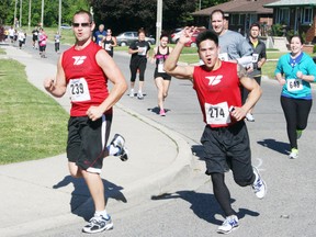 Some of the record number of runners who participated in the 15th annual Dairy Capital Run on Sunday, May 26, 2013, in support of the Woodstock Hospital Foundation cheer as they round a corner on the course. JOHN TAPLEY/INGERSOLL TIMES/QMI AGENCY