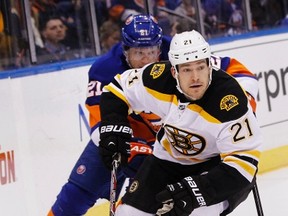 Boston Bruins' Andrew Ference (21) skates up the ice past New York Islanders' Kyle Okposo, February 26, 2013. (REUTERS/Shannon Stapleton)