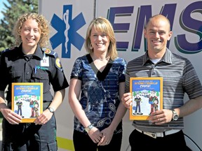 Author Amy McCann (left) launches her new safety colouring book with Regional EMS Foundation executive director Laura LaValley and narrator Paul Therrien outside the Alberta Health Services EMS Office on Monday. 
Elizabeth McSheffrey/Daily Herald-Tribune