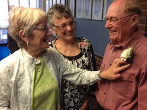 Isabelle Love, left, adjusts the boutonniere on her husband Lyle Love, one of Owen Sound's volunteers of the year, as fellow volunteer of the year recipient Jean Wilson looks on.