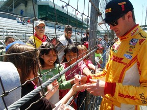 Ryan Hunter-Reay signs autographs for school children during a practice session at Indianapolis Motor Speedway. The Andretti Autosport driver was in control at the Indy 500 on Sunday before a couple of late yellow caution flags derailed him. (Reuters)