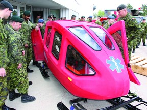 Medics with 1 Canadian Field Hospital look over the Snowbulance, a unique polyethylene-constructed rescue unit designed for arctic conditions. The unit will be training on the equipment in the coming year.